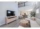 Bright living room with vaulted ceiling, L-shaped sofa, and modern media console at 1608 Sunset Wind Loop, Oldsmar, FL 34677