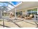 Relaxing screened patio with wicker furniture and views of the backyard at 18119 Diamond Cove Ct, Tampa, FL 33647