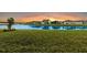 Community lake view at sunset with homes reflecting in the water at 19771 Ship Wheel Way, Land O Lakes, FL 34638