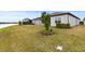 Landscaped backyard with grassy area and water view at 19771 Ship Wheel Way, Land O Lakes, FL 34638