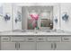 Elegant bathroom featuring double vanity, granite countertop, and large mirror at 19771 Ship Wheel Way, Land O Lakes, FL 34638