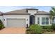 Single-story home with gray exterior, two-car garage, and manicured landscaping at 19771 Ship Wheel Way, Land O Lakes, FL 34638