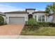 One-story house with gray siding, brown roof, and a brick paver driveway at 19771 Ship Wheel Way, Land O Lakes, FL 34638