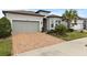 Single-story home with gray siding, brown roof, and a brick driveway at 19771 Ship Wheel Way, Land O Lakes, FL 34638