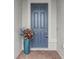 Dark blue front door with a teal planter and brick walkway at 19771 Ship Wheel Way, Land O Lakes, FL 34638