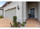 Gray garage door and a dark blue front door with brick walkway at 19771 Ship Wheel Way, Land O Lakes, FL 34638