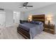 Spacious bedroom with wood bed frame, gray bedding, and ceiling fan at 220 Belleview Blvd # 607, Belleair, FL 33756