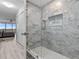 Updated shower with marble-like wall tiles and glass enclosure at 220 Belleview Blvd # 607, Belleair, FL 33756