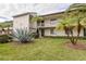 Condo building exterior with lush landscaping and palm trees at 225 Nina Way # 225, Oldsmar, FL 34677