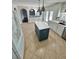 Open kitchen with an island, stainless steel appliances, and white cabinets at 24932 Ravello St, Land O Lakes, FL 34639