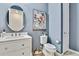 Bathroom features a white vanity, toilet, and large framed art at 31627 Colada Drift Way, Wesley Chapel, FL 33545