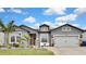 Gray house with stone accents, landscaping, and a two-car garage at 31627 Colada Drift Way, Wesley Chapel, FL 33545