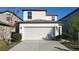 Two-story house with a white exterior, two-car garage, and landscaping at 4410 Summer Savory St, Tampa, FL 33619