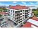 Aerial view of a condo building with red tile roofs and ample parking at 6365 Bahia Del Mar Blvd # 604, St Petersburg, FL 33715