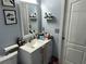 Bathroom vanity with a white sink and countertop, framed mirror, and storage at 6905 Sotra St, Wesley Chapel, FL 33545