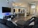 Open living room and kitchen with dark sofas at 6905 Sotra St, Wesley Chapel, FL 33545