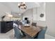 Open concept dining room adjacent to living room with a rustic wood table and modern chandelier at 731 Brittany Park Blvd, Tarpon Springs, FL 34689