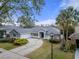 Single-story home with gray exterior, curved driveway, and palm trees at 810 Sandringham Ln, Lutz, FL 33549