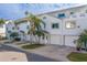 White two-story townhouses with attached garages and palm trees at 905 Hidden Harbour Dr, Indian Rocks Beach, FL 33785