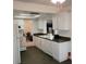 White kitchen with dark countertops and a view into the living room at 9608 41St N St # 2, Pinellas Park, FL 33782