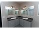 Updated bathroom with double vanity and gray cabinets at 12816 Midvale Ave, New Port Richey, FL 34654