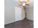 Bedroom with ceiling fan, double door closet, and wood-look floors at 12816 Midvale Ave, New Port Richey, FL 34654