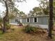 Gray manufactured home with wood steps and landscaping at 12816 Midvale Ave, New Port Richey, FL 34654