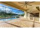 Outdoor kitchen and patio area with pool and lake view at 13819 Swiftwater Way, Bradenton, FL 34211