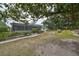 Landscaped backyard with lush greenery and screened enclosure at 1601 Woodmar Dr, Sun City Center, FL 33573