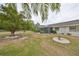 Side yard view of house with mature trees and landscaping at 1601 Woodmar Dr, Sun City Center, FL 33573