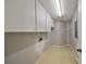 Bright laundry room with overhead cabinets and shelving at 1601 Woodmar Dr, Sun City Center, FL 33573