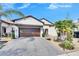 Two-story house with a brown garage door and palm trees at 16909 April Plush Dr, Wimauma, FL 33598