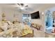 Main bedroom with king bed, TV, and access to patio at 16909 April Plush Dr, Wimauma, FL 33598