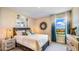 Serene bedroom with a rustic bed frame and coastal-themed artwork and window view at 17932 Tavernside Trl, Lakewood Ranch, FL 34211