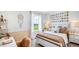 Cozy bedroom with a white bed frame, beachy decor, and a window seat at 17932 Tavernside Trl, Lakewood Ranch, FL 34211