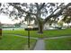 Pathway through grassy area towards community pool and tennis court at 1824 Bough Ave # 3, Clearwater, FL 33760