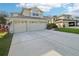 Two-story house with a three-car garage and spacious driveway at 1919 Blue River Rd, Holiday, FL 34691