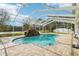 Inviting screened pool with a stone waterfall feature at 1919 Blue River Rd, Holiday, FL 34691