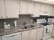 Modern kitchen with granite countertops and white cabinets at 255 Dolphin Pt # 511, Clearwater Beach, FL 33767