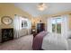 Bright bedroom with a queen-size bed, ceiling fan, and access to a balcony at 274 Madeira Cir, St Petersburg, FL 33715