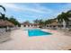 Community pool with lounge chairs and thatch umbrellas at 274 Madeira Cir, St Petersburg, FL 33715