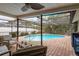 Relaxing pool area with patio furniture and screened enclosure at 3048 Orchard Dr, Palm Harbor, FL 34684