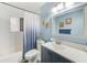 Bathroom with a blue vanity, marble countertop, and a shower/tub combo at 3113 Chamblee Ln, Clearwater, FL 33759