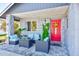 Relaxing front porch with red door and patio furniture at 3113 Chamblee Ln, Clearwater, FL 33759