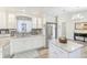 Bright kitchen, featuring white cabinets, granite island, and stainless steel appliances at 3113 Chamblee Ln, Clearwater, FL 33759
