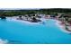 Aerial view of a sparkling crystal lagoon with beach access and lounge chairs at 32535 Turtle Grace Loop, Wesley Chapel, FL 33545