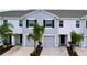 Two-story townhome with gray siding, two-car garage, and landscaping at 32535 Turtle Grace Loop, Wesley Chapel, FL 33545