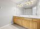 Double vanity bathroom with light wood cabinets and a large mirror at 4842 Pond Ridge Dr, Riverview, FL 33578