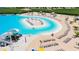 Crystal Lagoon pool with sandy beach, lounge chairs, and water features at 5328 Stoic Vale Dr, Wimauma, FL 33598