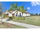 View of a single-story home's side with palm trees and well-manicured lawn at 5328 Stoic Vale Dr, Wimauma, FL 33598